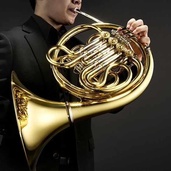 A YHR-871II French or Double Horn, played by a formally dressed man