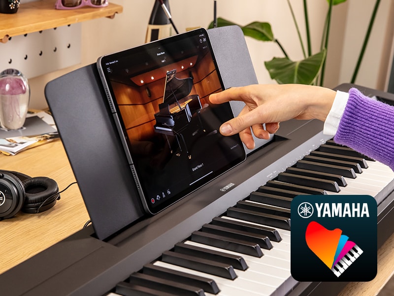 The Yamaha “Smart Pianist” app icon, together with a tablet placed on the music stand of the P-145