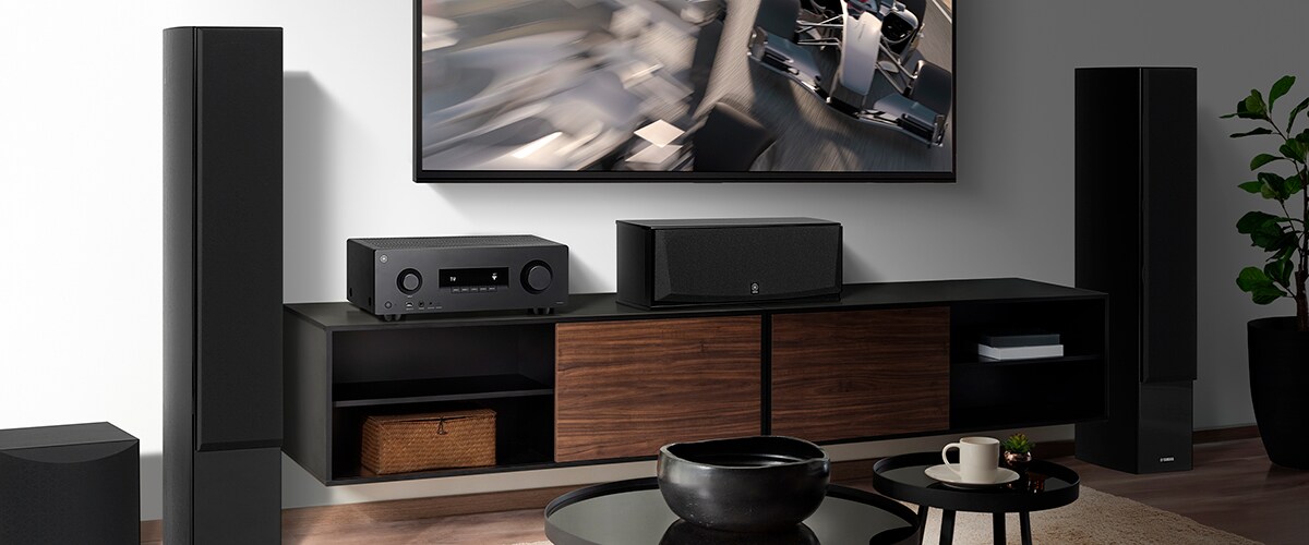 The RX300A, a center speaker, front speakers and a subwoofer in a room.
