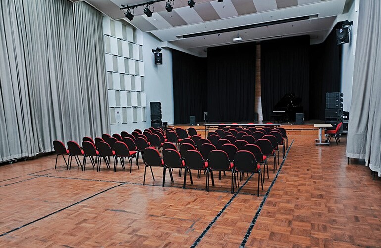Jakarta training facility auditorium with stage, projection screen, and seating.