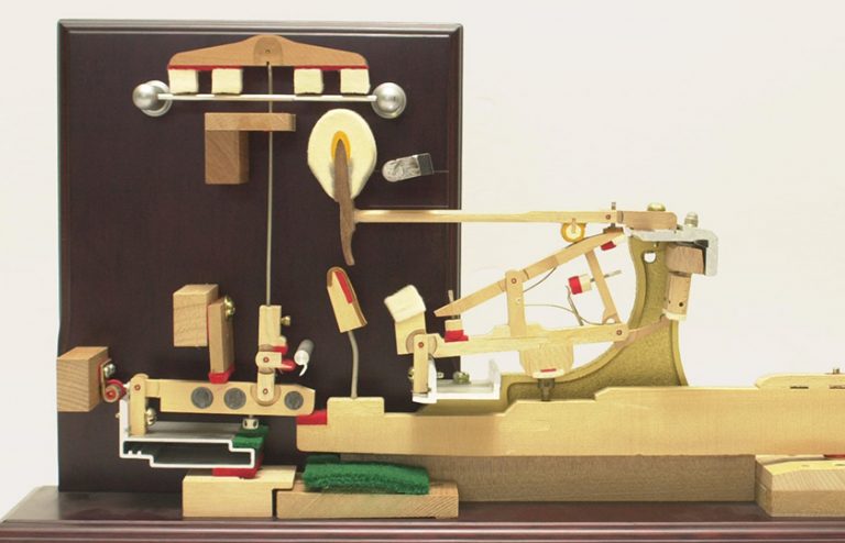 A complex series of levers are attached to each key of an acoustic piano.