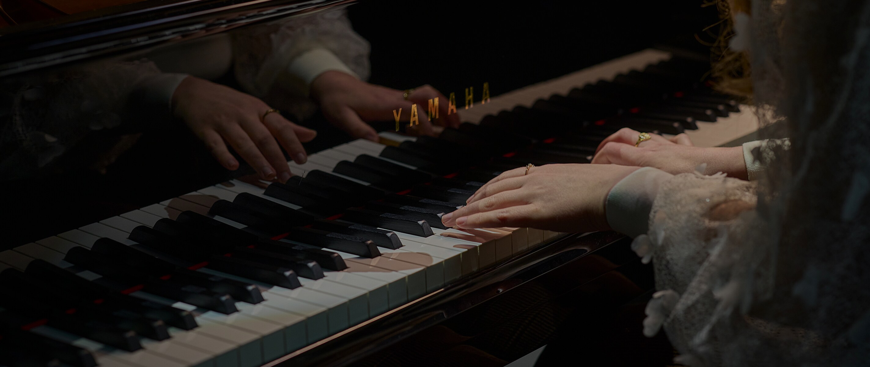 A woman playing an Yamaha Grand Piano dramatically on a stage.